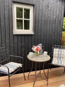 a table with a vase of flowers and two chairs at Lykkeholms Bella Vista in Spottrup +10 photos