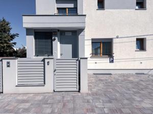 a white house with a gate in front of it at L Apartment II in Maribor