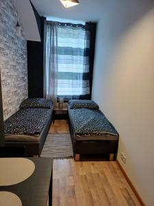 two beds in a room with a window at Rajca Room's - Pokoje przy Jasnej Górze in Częstochowa
