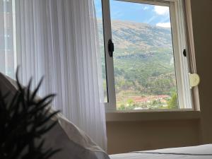 a bedroom with a window with a view of a mountain at Casa Di SI in Përmet