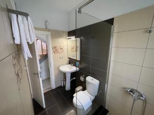 a small bathroom with a toilet and a sink at Casa Di SI in Përmet +21 photos