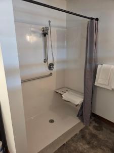 a shower with a glass door in a bathroom at The Mill Hotel in Fergus Falls