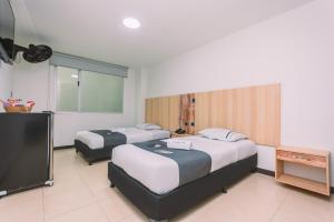 a hotel room with two beds and a television at Mandala Medellín Centro By GyC Hotels in Medellín