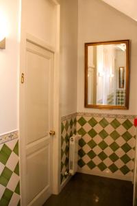 a bathroom with a mirror and a checkerboard wall at Monte da Lua in Sintra