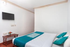 コダイカナルにあるHotel O RGP Residency Kodaikanal lakeのベッドと薄型テレビのある寝室 +22枚の写真