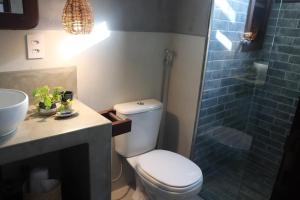 a bathroom with a toilet and a sink and a shower at Zenhousepipa in Pipa