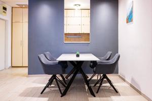 a table and chairs in a room with a blue wall at Brazos Apartment in Kotor