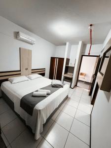 a bedroom with a large bed with towels on it at Harbor Inn Jaraguá in Jaraguá do Sul