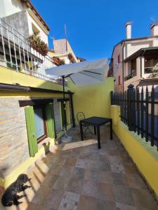 a patio with a black table and an umbrella at Ca'del Porto in Marano Lagunare