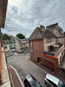 a view of a city street with cars parked on the road at Le Victor Hugo in Gien