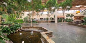 a courtyard with a fountain in a building with trees at FairBridge Hotel by Concord Plaza in Concord