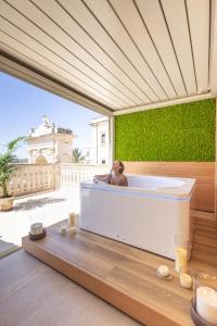 a woman sitting in a bath tub in a room at Noto Boutique Hotel in Noto +192 photos