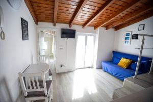 a living room with a blue couch and a tv at Duplex San Fedele in Como