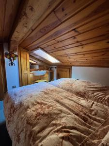 a large bed in a room with wooden ceilings at Attico Cortina D'Ampezzo in Cortina dʼAmpezzo