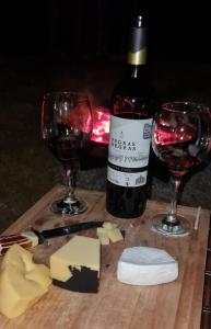 una botella de vino y dos copas de vino tinto en Recanto da Natureza, en Itabirito