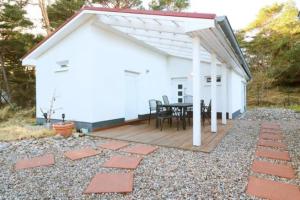 - un patio avec une table et un bâtiment blanc dans l'établissement Haus Oertel Koje 23 Trassenheide Usedom, à Trassenheide