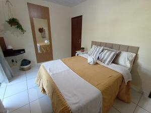 a bedroom with a large bed with white sheets and pillows at Estúdio Raiz da Mata in Nova Friburgo