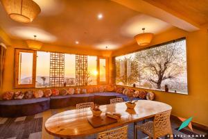 a living room with a table and a couch at Zostel Homes Bir in Bīr