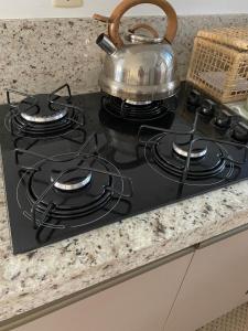 a stove top with a tea kettle on top of it at Duplex Acolhedor - Duas quadras do Mar Centro in Tramandaí +14 photos
