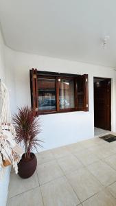 a room with a potted plant and a window at Duplex Acolhedor - Duas quadras do Mar Centro in Tramandaí