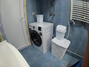 a washing machine in a bathroom with a toilet at Roomer Prishtina Hostel in Prishtinë