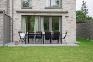 Wohnkultur - Ferienhaus für 10 mit Garten und 5 Schlafzimmern في فيسلوخ: مجموعة من الكراسي وطاولة على الفناء