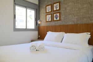 ein Schlafzimmer mit einem großen weißen Bett mit Handtüchern darauf in der Unterkunft Casa Pantuso no coração de BH in Belo Horizonte + 79 Fotos