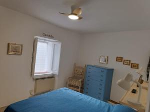 a bedroom with a blue bed and a window at La Casa del Castello in Alvito