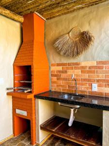 cocina con fregadero y horno de ladrillo en Casa Hau Oli, en Fortim
