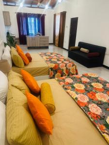 a room with three beds with pillows and a couch at TJ lanka homestay in Moratuwa