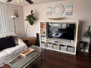 a living room with a couch and a tv at Downtown Sunsets Convention Center in San Diego