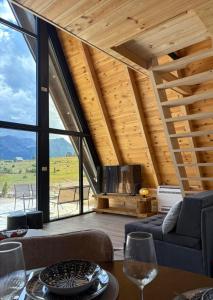 a room with a couch and a table with wine glasses at Vista Montis in Žabljak