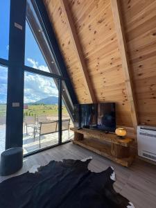 a living room with a fireplace and a large window at Vista Montis in Žabljak