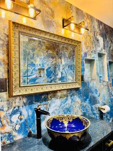 a bathroom with a blue sink and a painting on the wall at Luxury Home -Sleeps 8- Pet OK- St. Cloud - Orlando in Saint Cloud +21 photos