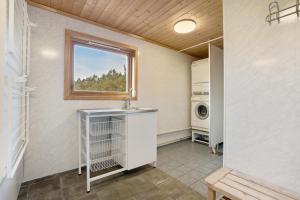 eine Waschküche mit einem Waschbecken und einem Fenster in der Unterkunft Mortenhytta, Valevåg in Valevåg