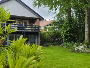 a house with a lawn in front of it at Oasen - hyggelig lejlighed in Videbæk +10 photos