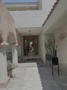 Un pasillo de un edificio con un banco y una puerta. en Santa Madre B&B, en San Luis Potosí
