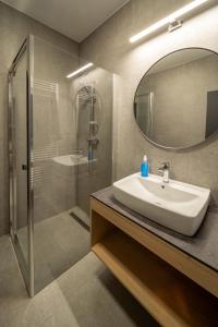 a bathroom with a sink and a shower and a mirror at The Cabin Retreat Piešťany 