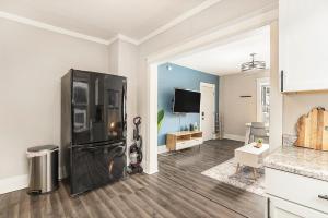 a kitchen with a black refrigerator in a room at The Metropolitan Manor-new Corporate Apt Downtown in Grand Rapids