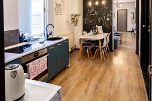 a kitchen with a sink and a table with chairs at Nordic Villa Brasov - With Private Yard, BBQ & Free Parking, 4 km from City Center in Braşov