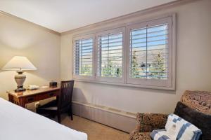 a bedroom with a desk and a bed and a window at Lodge Tower 482 in Vail