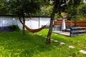 a hammock in a yard next to a deck at Nordic Villa Brasov - With Private Yard, BBQ & Free Parking, 4 km from City Center in Braşov