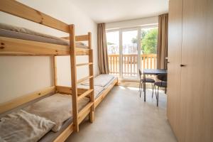 a bedroom with bunk beds and a table and a desk at The Cabin Retreat Piešťany  +73 photos
