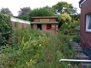 a garden with weeds and a building with a window at Haus der Kunst in Dülmen