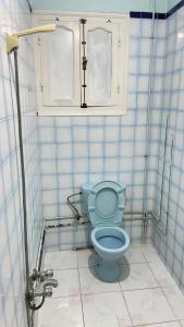 a bathroom with a blue toilet in a stall at Apparemment SIDI ABID in Al Hoceïma