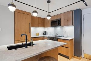 a kitchen with wooden cabinets and a sink at Lodge Tower 486 Two Bedroom Residence in Vail +22 photos