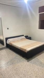 a bed in a bedroom with a light shining on it at Apparemment SIDI ABID in Al Hoceïma