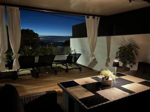 un soggiorno con tavolo e sedie su un balcone di Beachfront house Miamore - 10 m from the sea a Mrljane