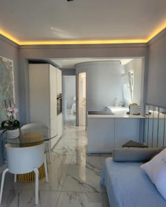 een slaapkamer met een bed en een tafel en een keuken bij Sea Front Madame blue 4-star two-room in ecological health design in Roquebrune-Cap-Martin