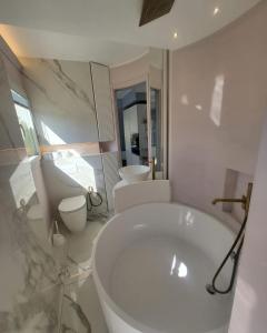 een witte badkamer met een bad en 2 toiletten bij Sea Front Madame blue 4-star two-room in ecological health design in Roquebrune-Cap-Martin